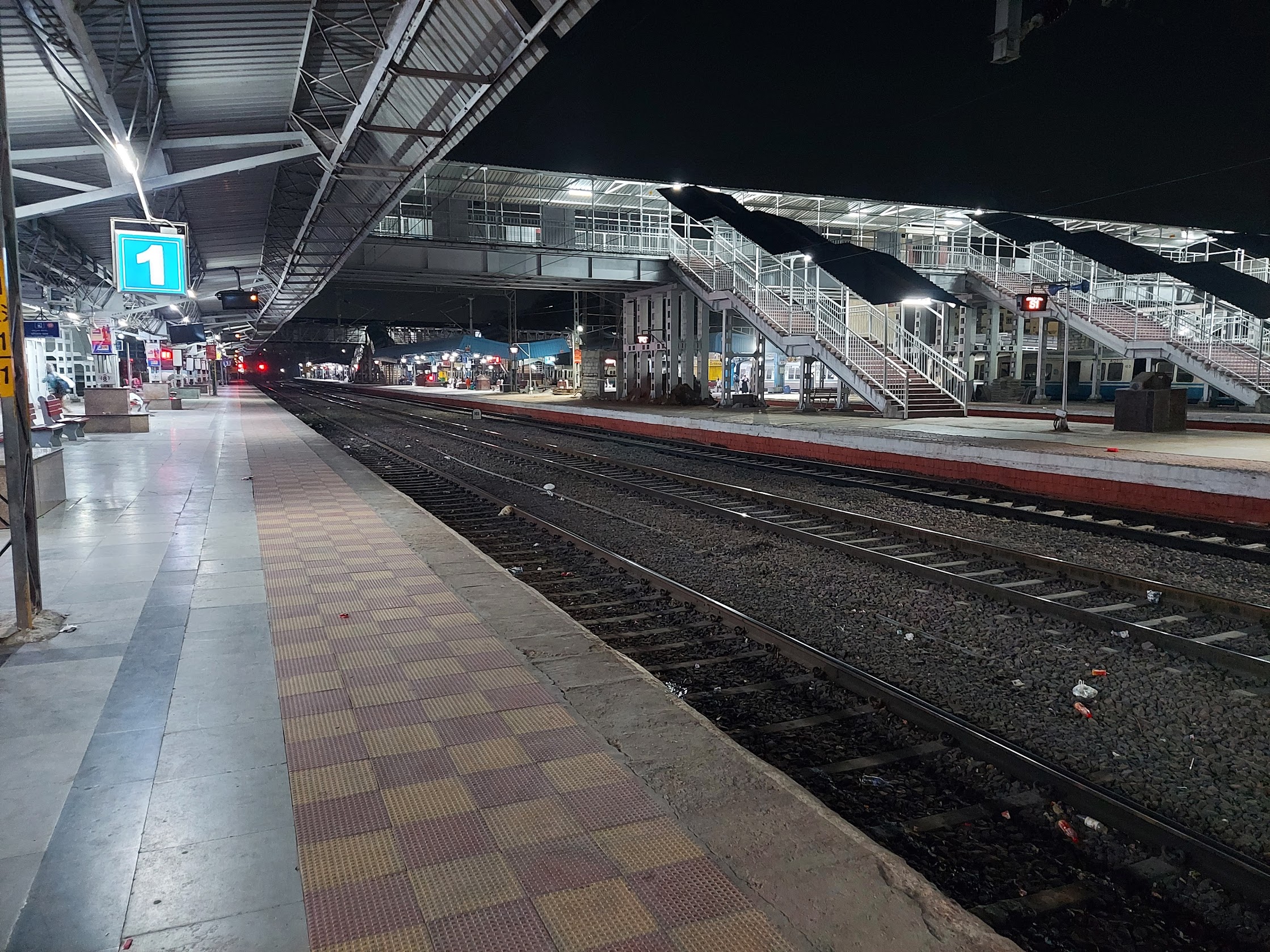 night view of a train station, with train tracks and the platform showing